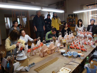 机上一面に並べられた博多人形たち。
粘土から整形はもちろんのこと着色、人形の表情はすべて手作業です。
